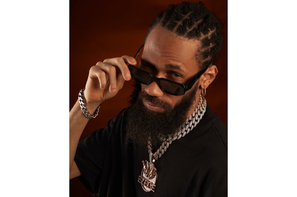 Nigerian rapper Phyno pulls down his sunglasses and winks at the camera.