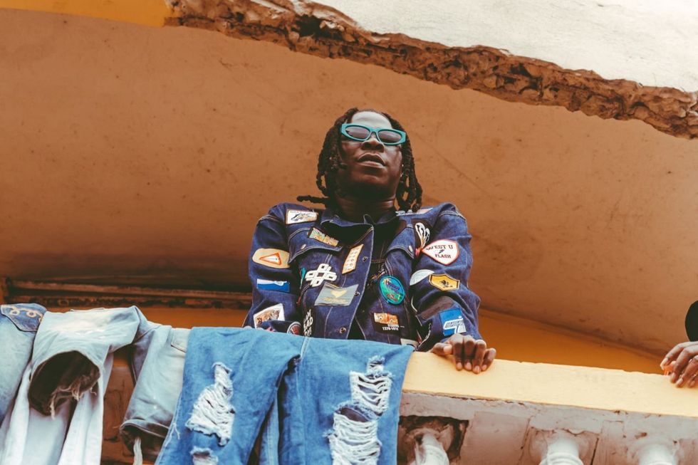 Stonebwoy peeks down from a balcony during the music video shoot for u201cJejerejeu201d in Ghana.