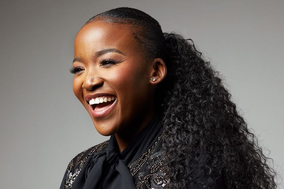 A photo of Ofentse Pitse wearing a black blouse and laughing.