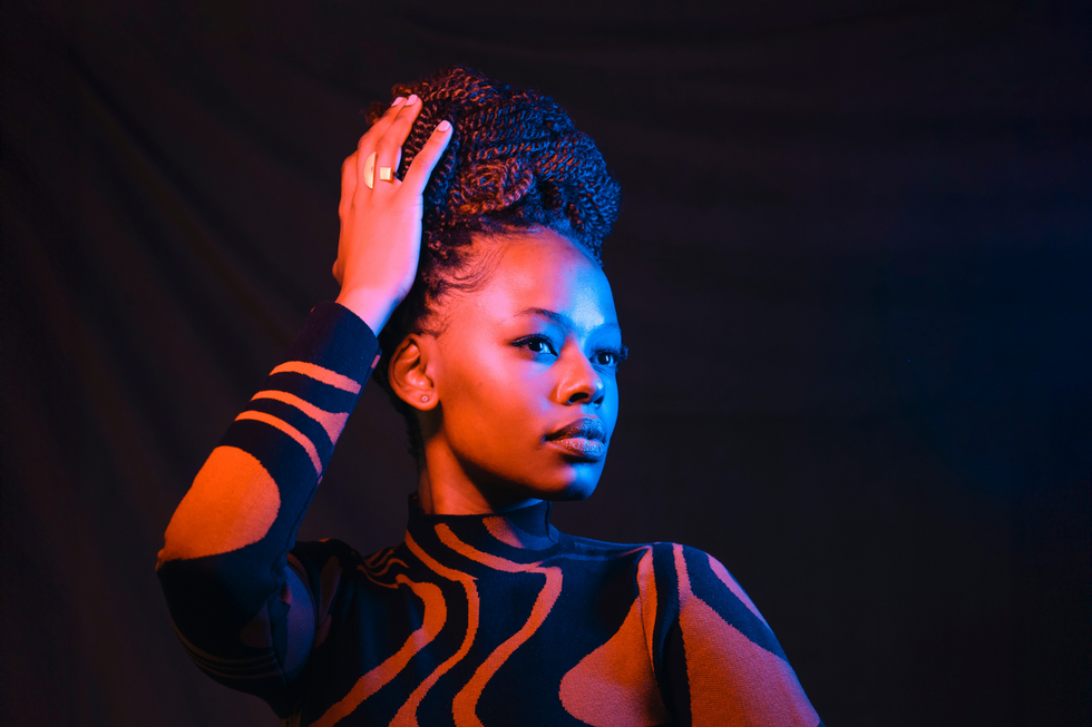 Naledi posing for a photo in a brown and black patterned dress.