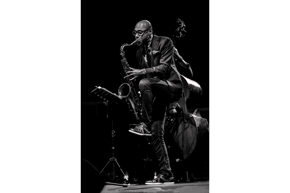 A monochrome image of Joshua Redman playing the saxophone.